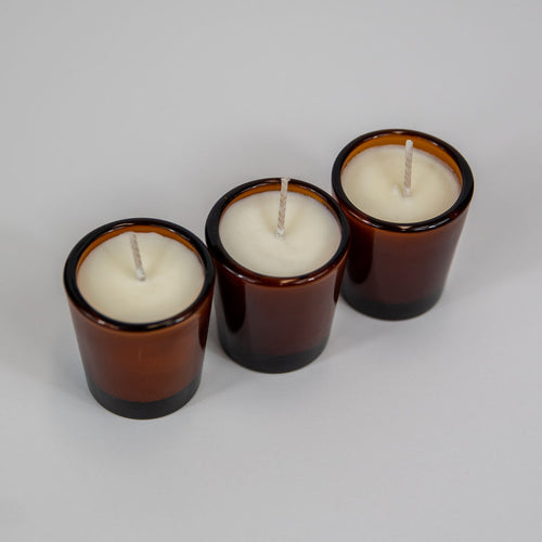 soy votives candles in amber glass jars